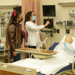 Nursing students exploring a hands on nursing lab