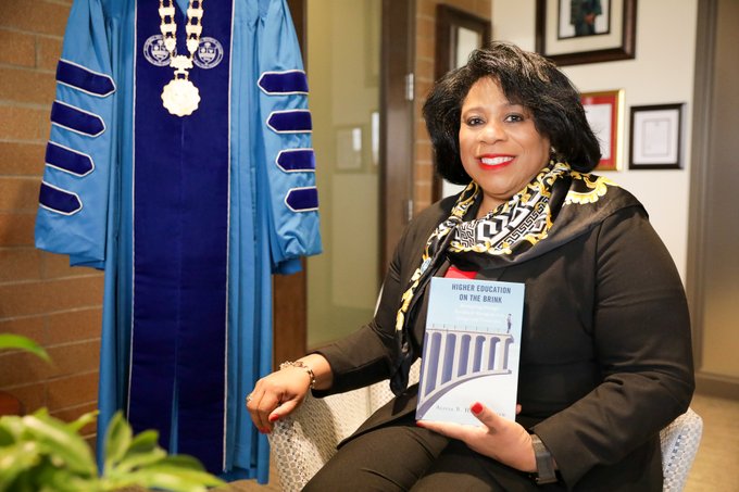Dr. Harvey-Smith holding her recently released book "Higher Education on the Brink: Reimagining Strategic Enrollment Management in Colleges and Universities".