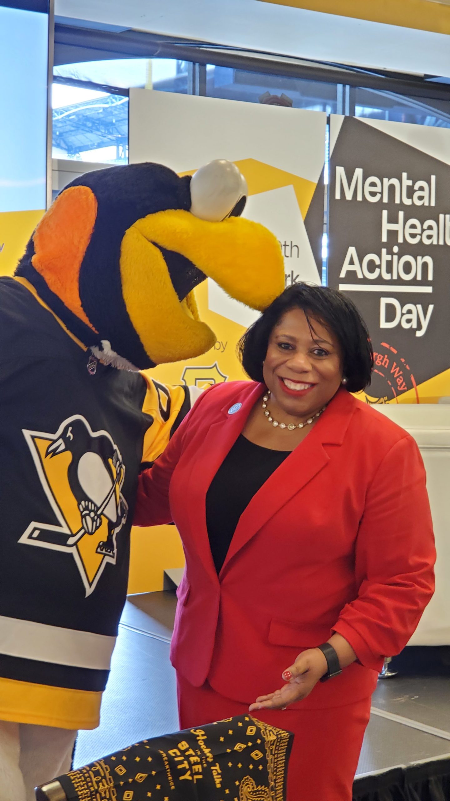 Dr. Harvey-Smith posing for a photo with the Pittsburgh Penguin's Mascot
