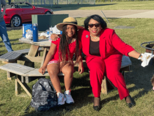 A photo of Dr. Harvey-Smith posing for a picture with Jonayah Boyd at the pride month finale camp fire.
