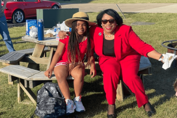 A photo of Dr. Harvey-Smith posing for a picture with Jonayah Boyd at the pride month finale camp fire.