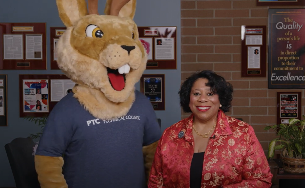 Dr. Alicia Harvey-Smith standing with the PTC mascot "Petey".