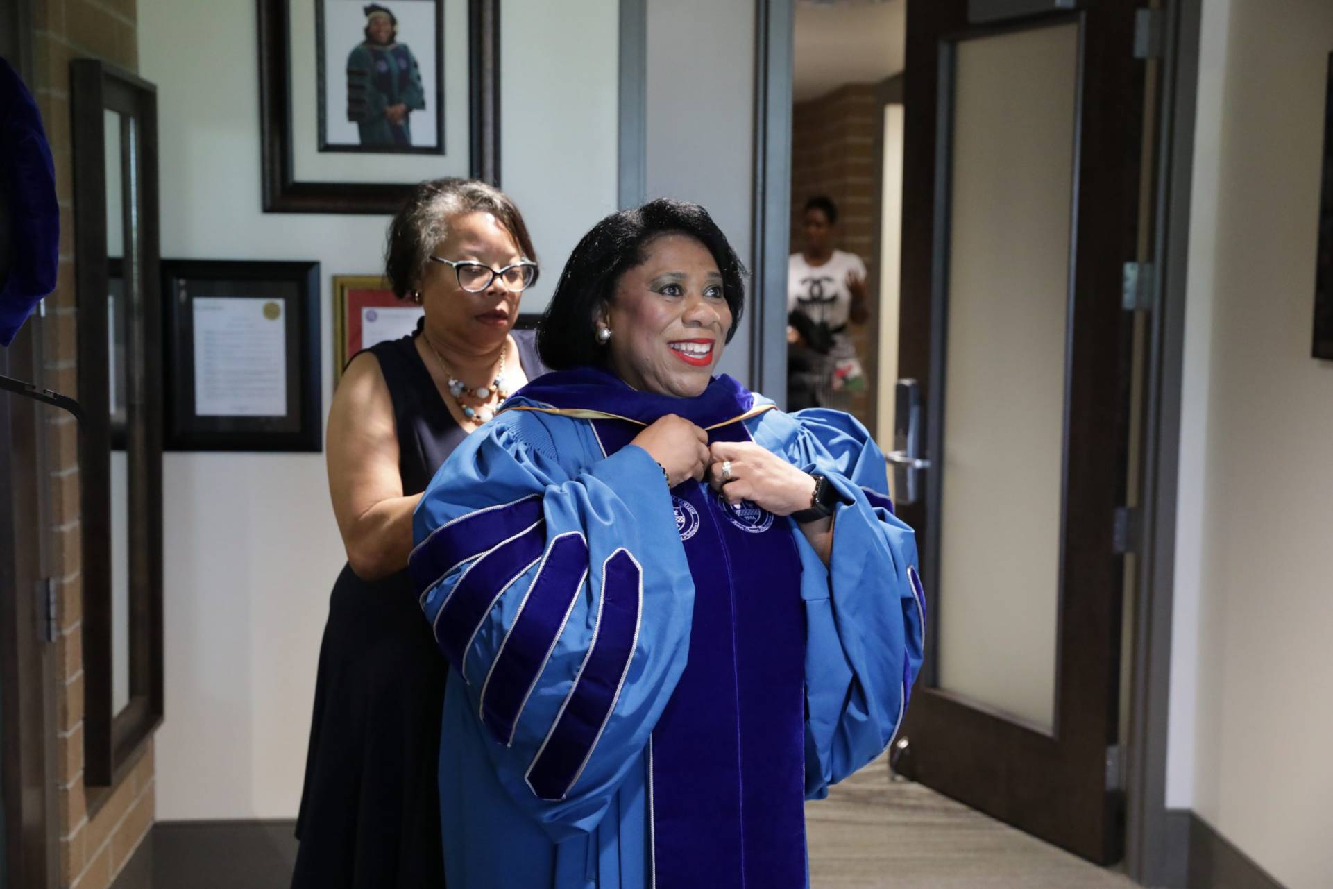 Dr. Harvey-Smith donning her gown for the Installation ceremony.